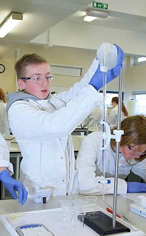 Chemistry demonstrator discussing with chemistry students
